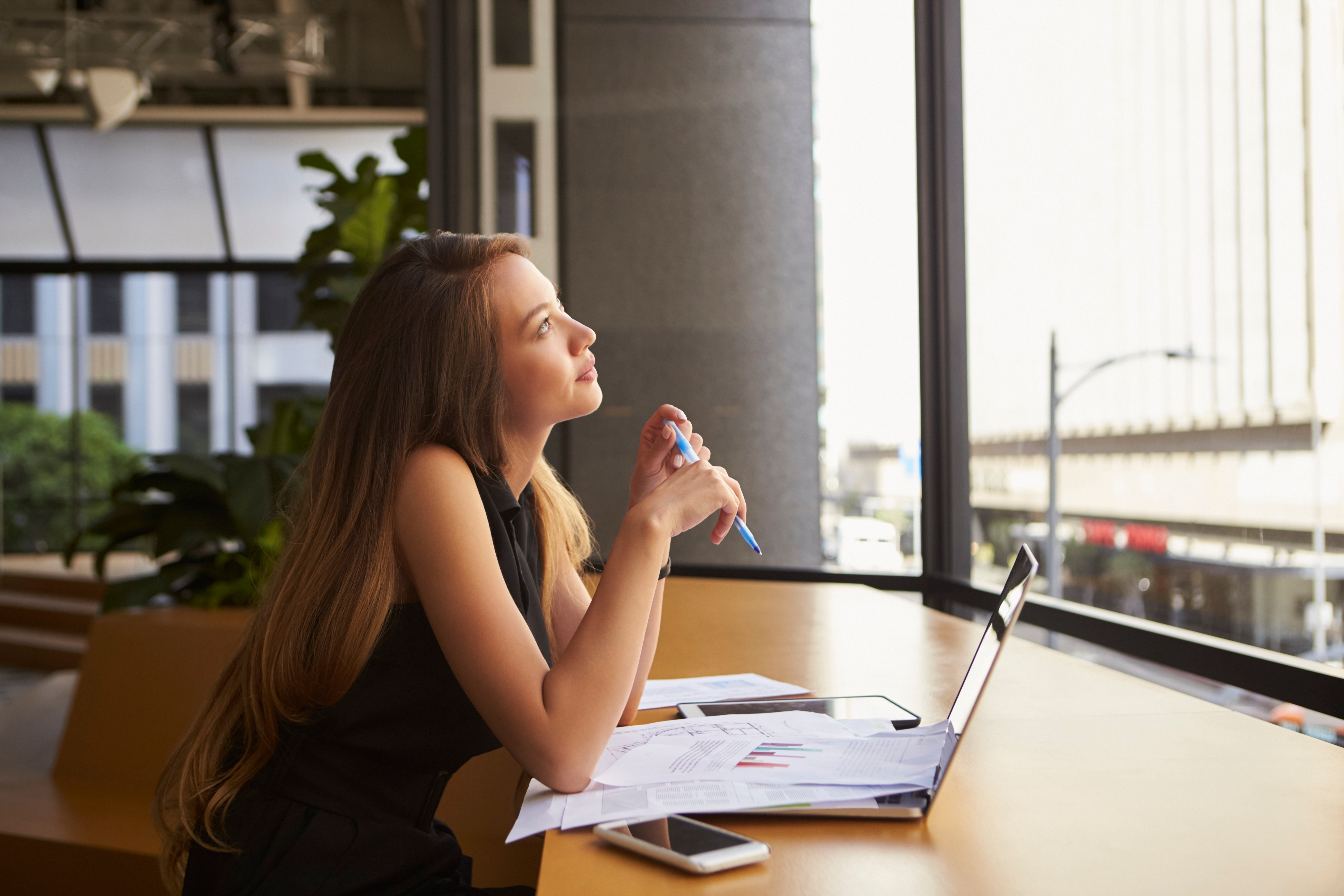 businesswoman-working-in-an-office-looking-out-of-PQN4WYD